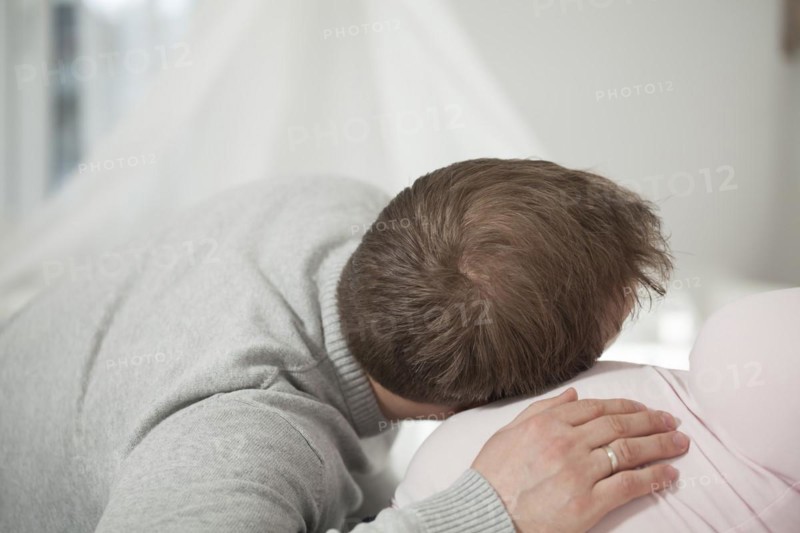 Man listening to the belly of a pregnant woman