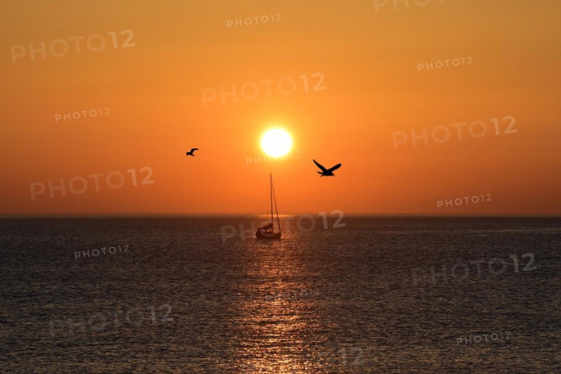 Sunset with sailboat on the Atlantic Ocean in Normandy