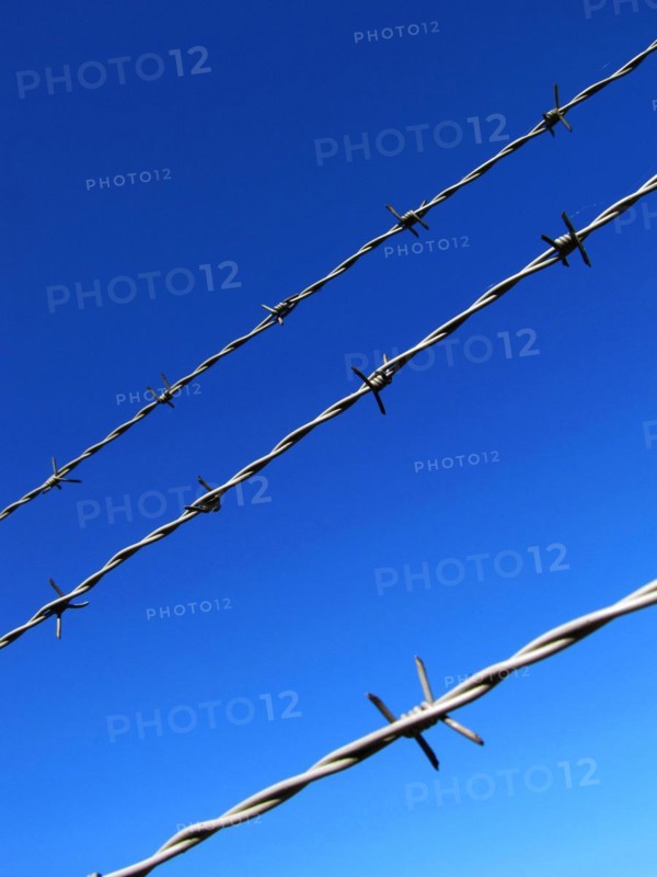 Barbed wire against a blue sky
