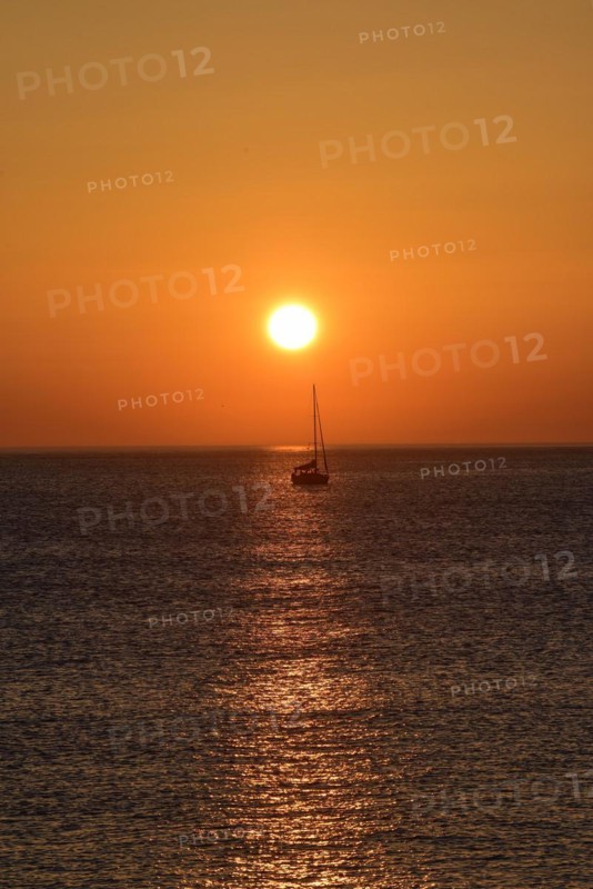 Sunset with sailboat on the Atlantic Ocean in Normandy