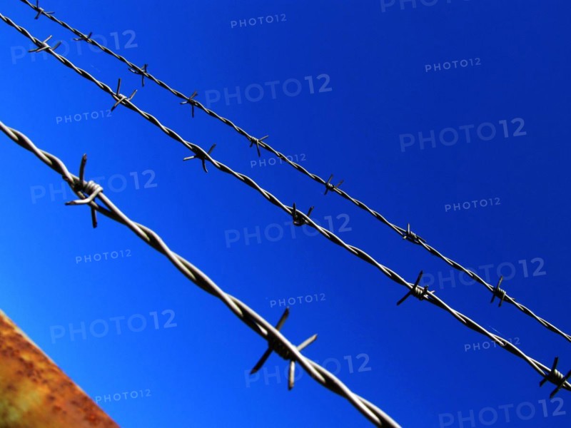 Barbed wire against a blue sky