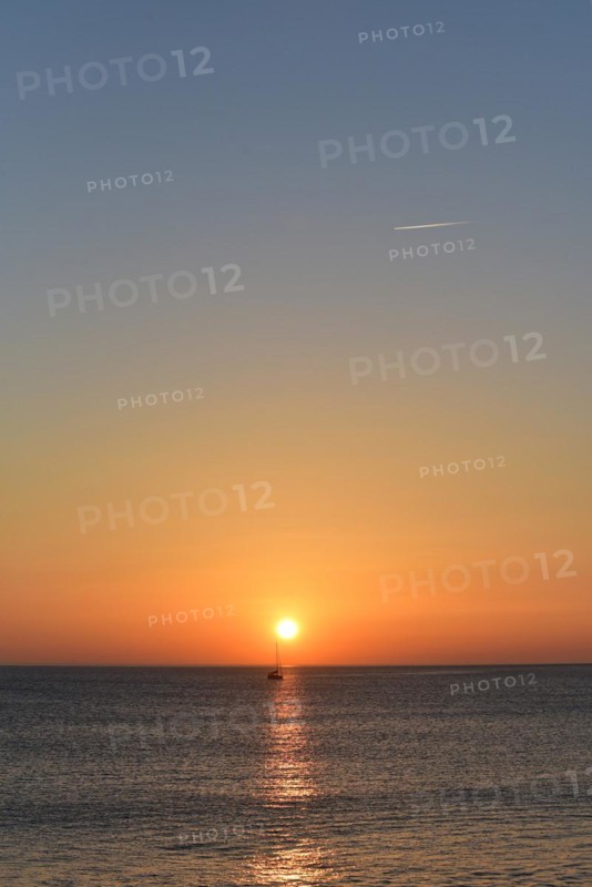 Sunset with sailboat on the Atlantic Ocean in Normandy