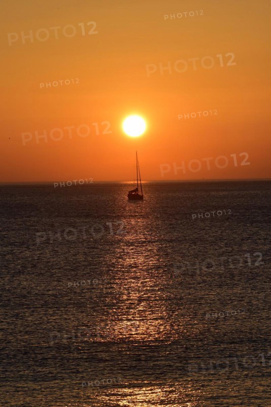 Sunset with sailboat on the Atlantic Ocean in Normandy