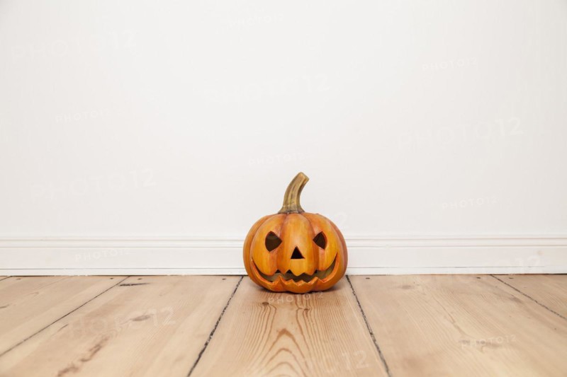 Grinning Clay Pumpkin on Wooden Floor