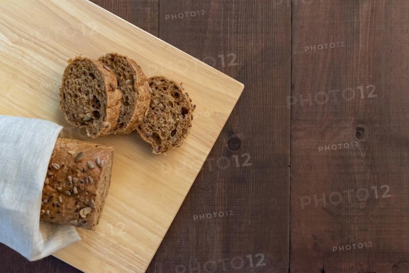 Sliced multi seeded baguette on a bread board