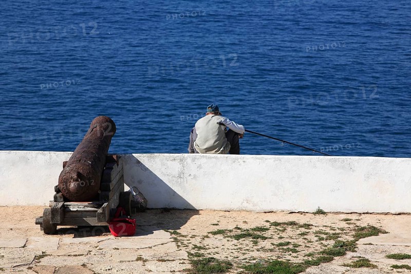 Cliff fishermen and historic cannon at the Fortaleza de Sagres