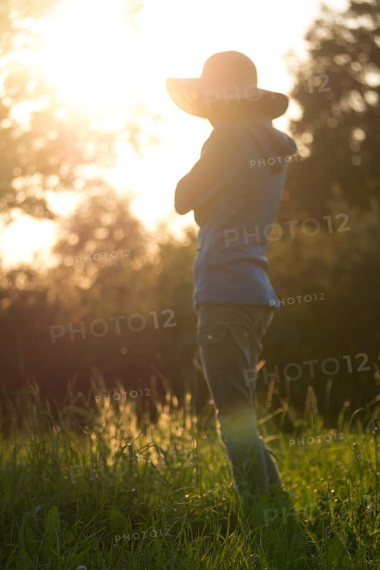 Young woman with hat relaxing in summer sunset sky outdoor
