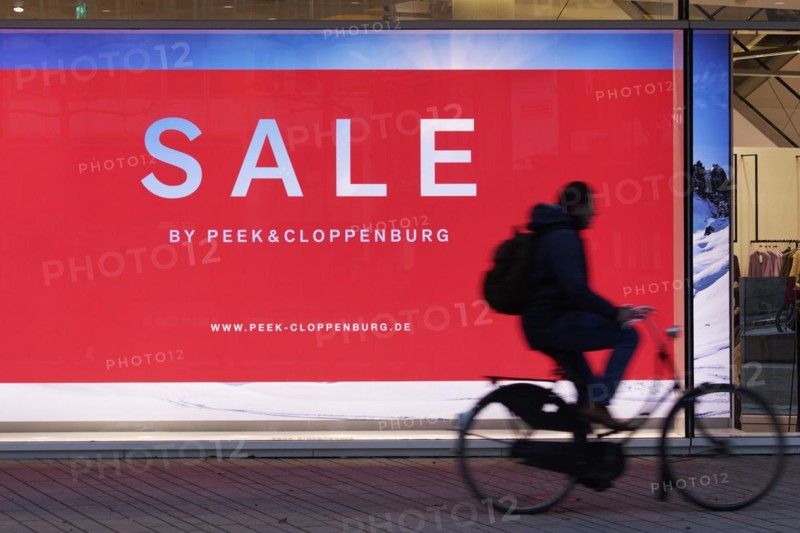 Illuminated shop window with poster Sale