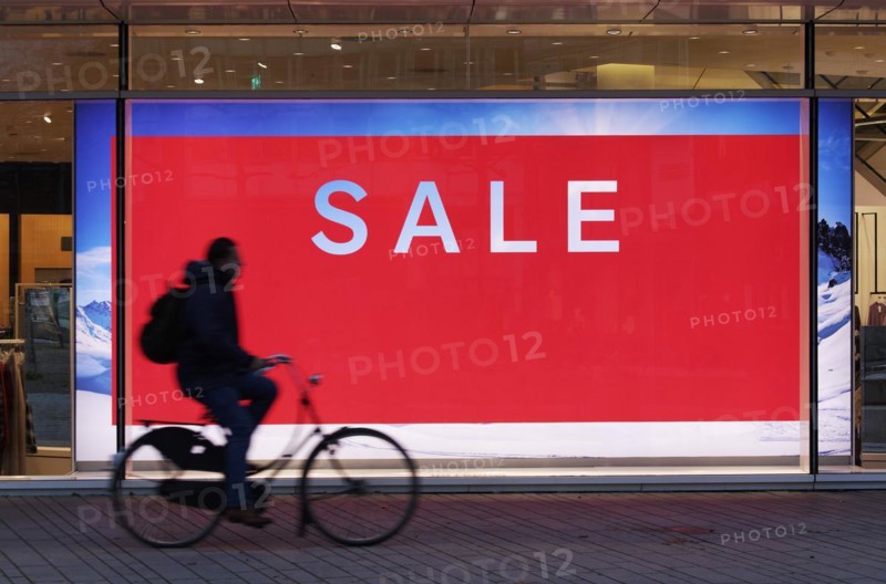Illuminated shop window with poster Sale