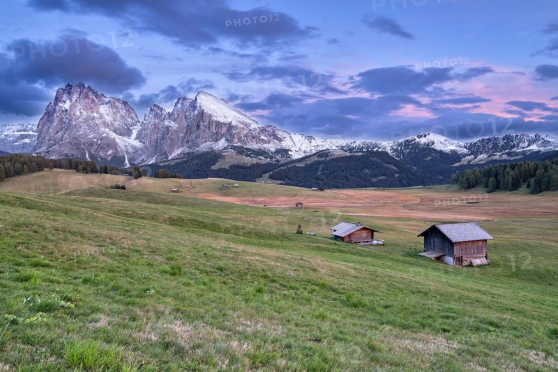 Alpine huts on autumnal alpine pastures in front of mountains