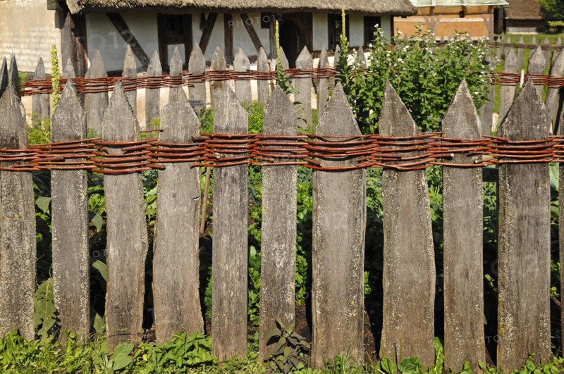 Old wooden fence connected with willow rods