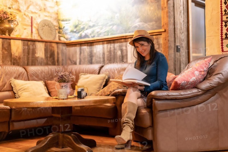 A pretty tourist with a hat and with a photo camera drinking tea in a cafe