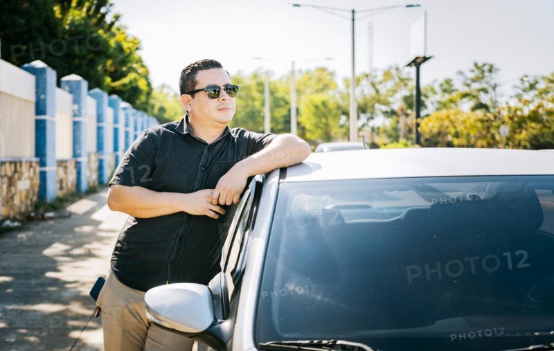Smiling driver leaning on the car door