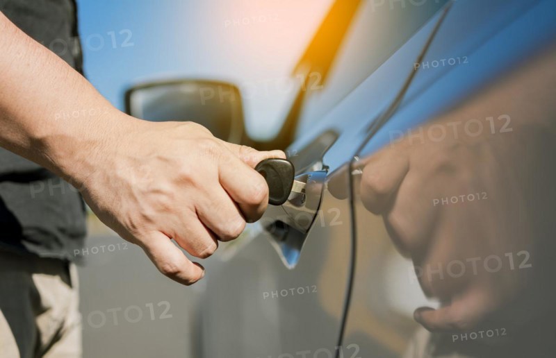 Hands with keys opening the car door