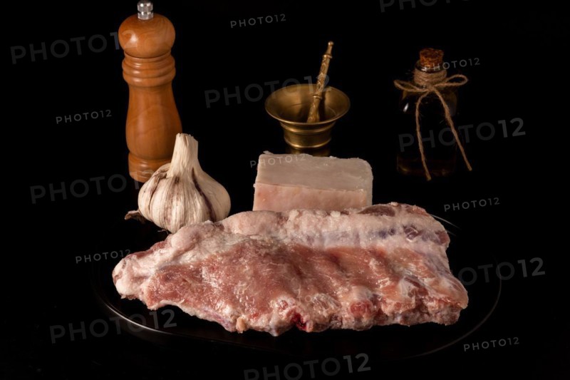 Fresh pork ribs and piece of bacon with garlic