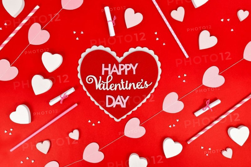 Valentines Day flat lay with heart with text Happy Valentines Day and heart ornaments on red background