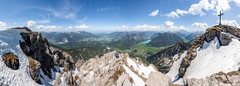 Hiker looking down from Thaneller to Plansee and eastern Lechtal Alps
