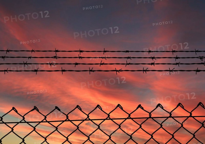 Chain link fence with additional barbed wire
