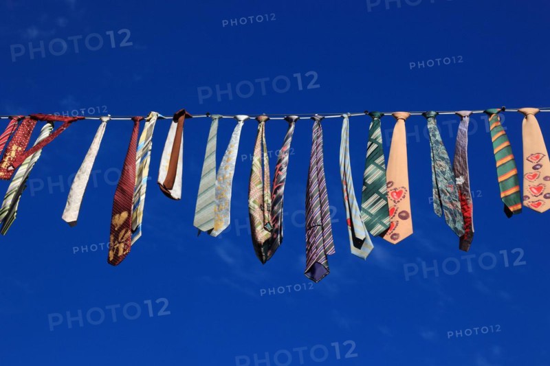 Many colourful ties hanging on a clothesline