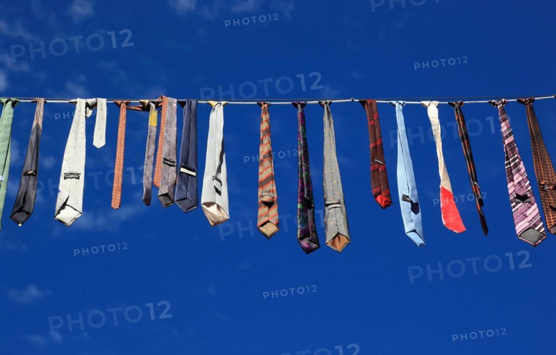 Many colourful ties hanging on a clothesline