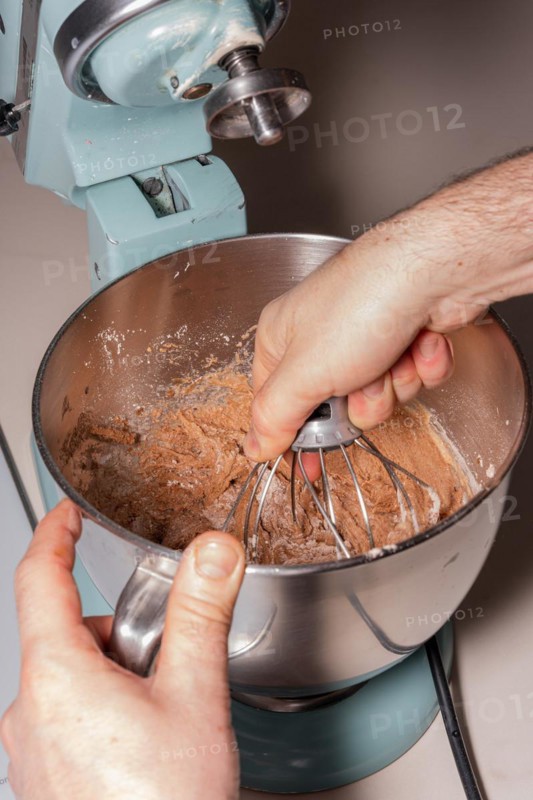 Hands of a man cooking a red velvet cake at home