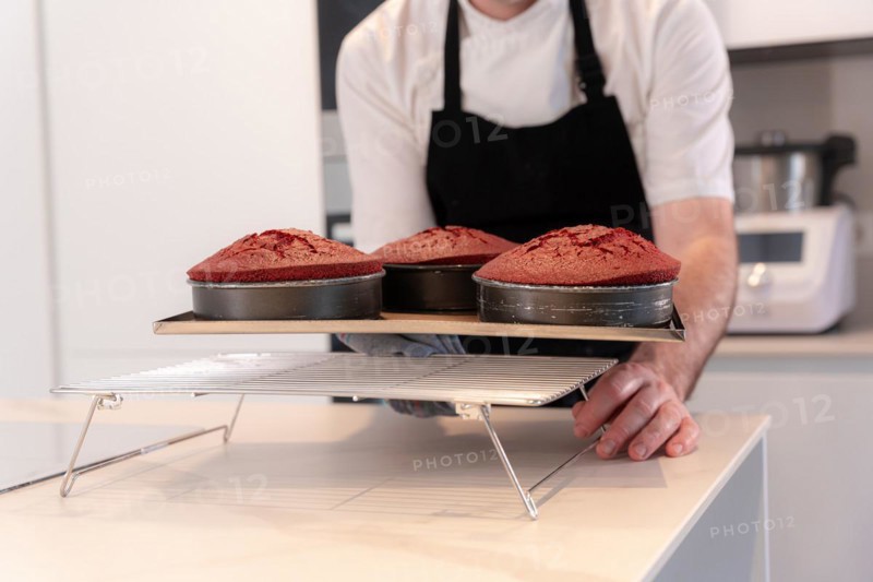 Hands of a man bakes a red velvet cake at home