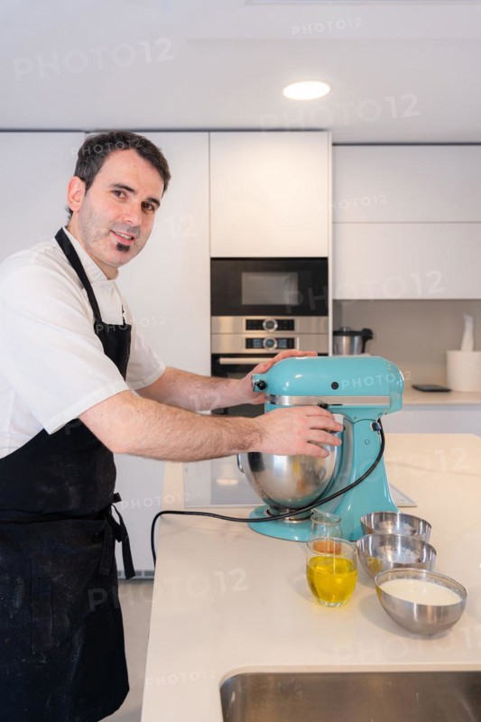 A man baker bakes a red velvet cake at home