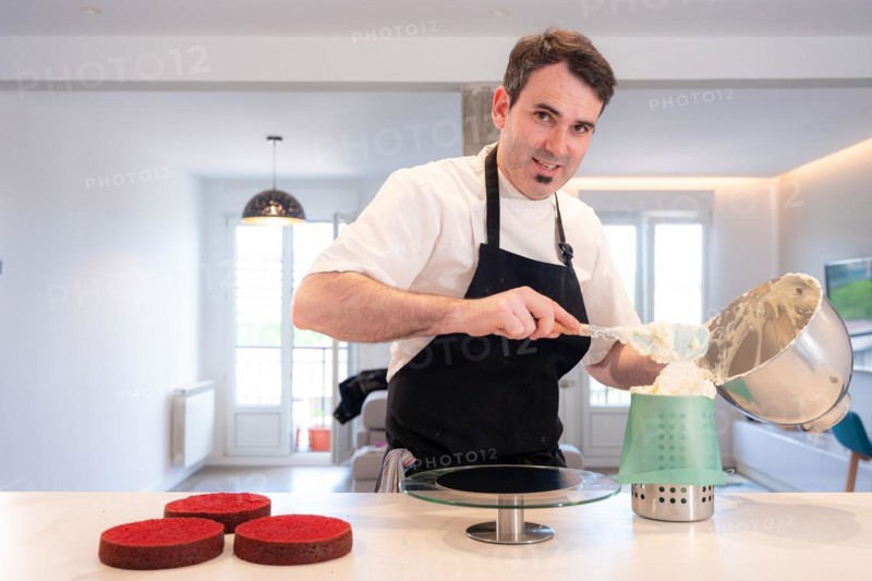 Hands of a man bakes a red velvet cake at home