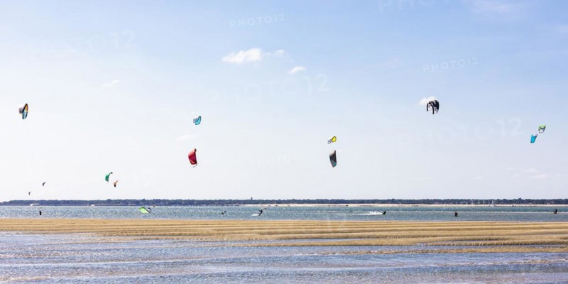 Group of kitesurfers kitesurfing in the Bay of Arcachon