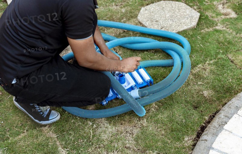 Man connecting the handle on the pool vacuum