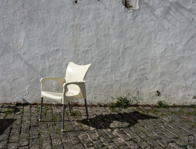 White plastic chair in front of old house facade