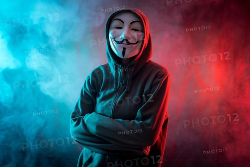 Hacker with anonymous mask with arms crossed with a menacing look