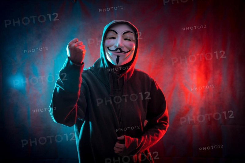Hacker with anonymous mask with his fist raised in symbol of fight