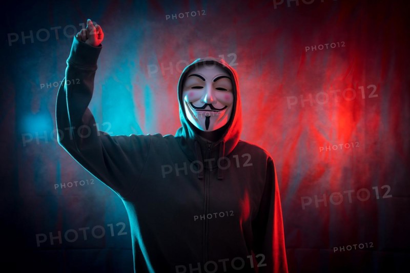 Hacker with anonymous mask with his fist raised in symbol of fight