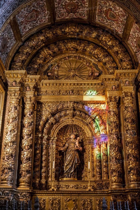 Coloured light shines on statue of saint