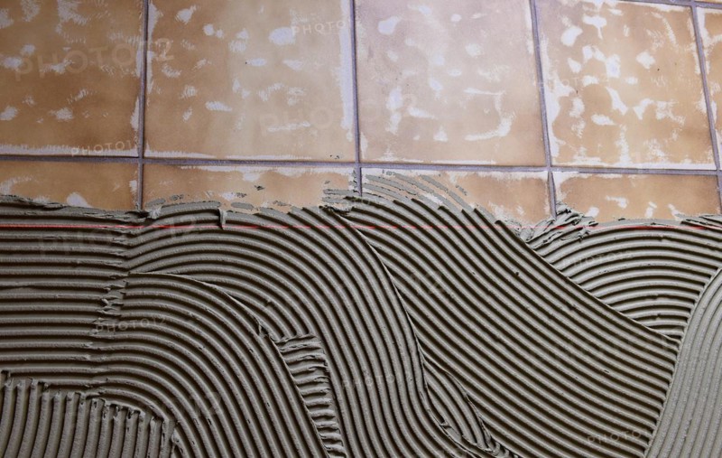 Tiler applied tile adhesive on old tiles