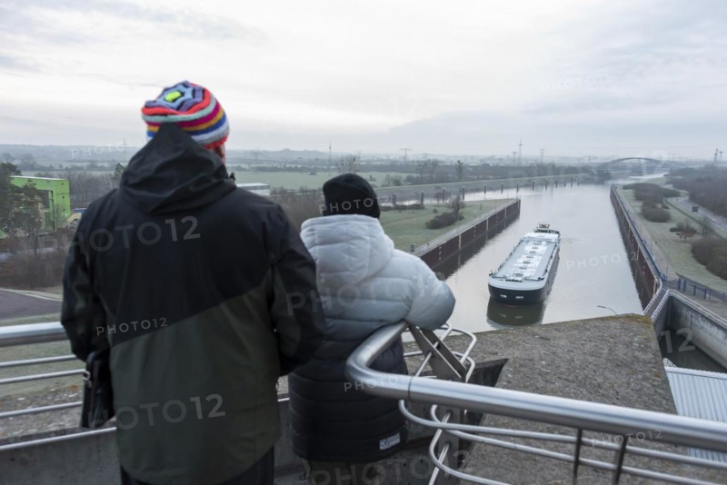 Onlookers look at a newly built tanker being manoeuvred by a push boat into Rothensee lock