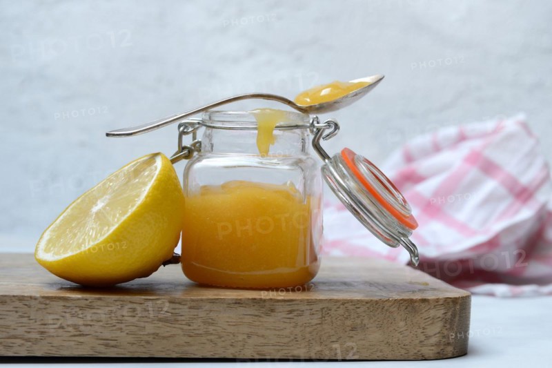 Glass jar with lemon curd and lemon
