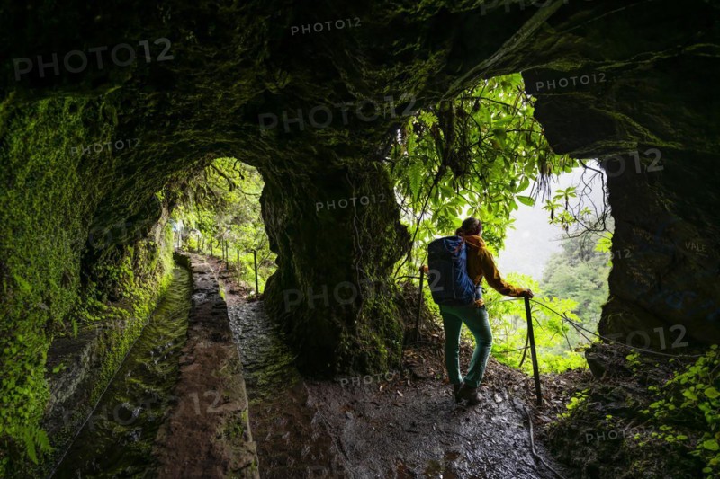 Hiker in a tunnel at PR9 Levada do Caldeirao Verde