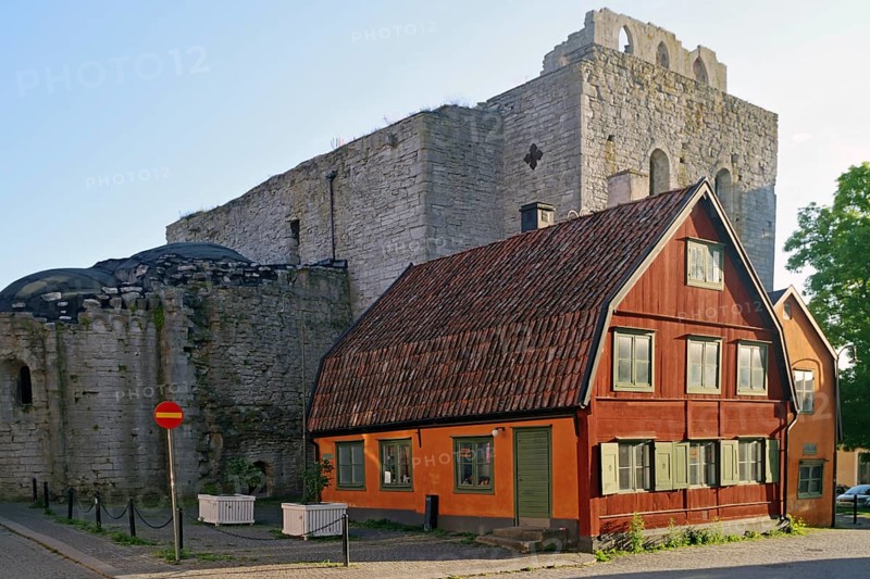 Small red house in front of medieval church ruin