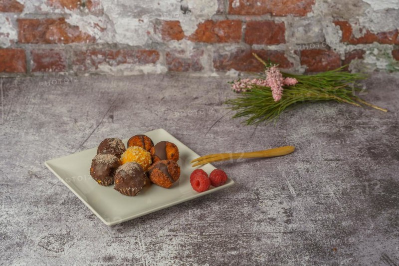 Sweet truffles of different flavors on a white ceramic plate