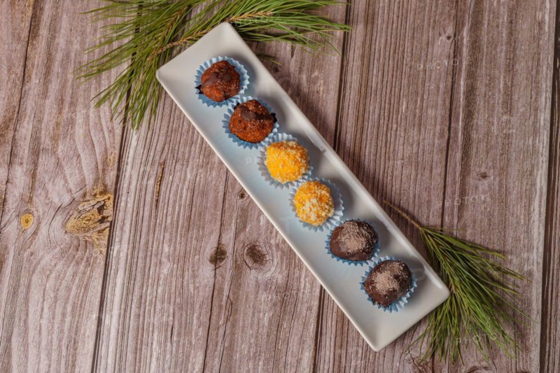 Sweet truffles in different flavors on a white ceramic tray