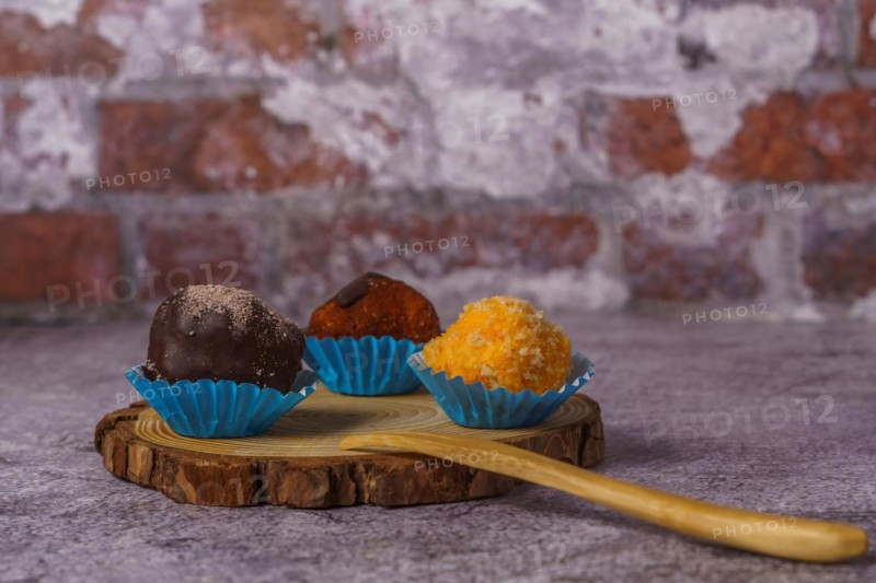 Truffles of different flavors on a wooden disk