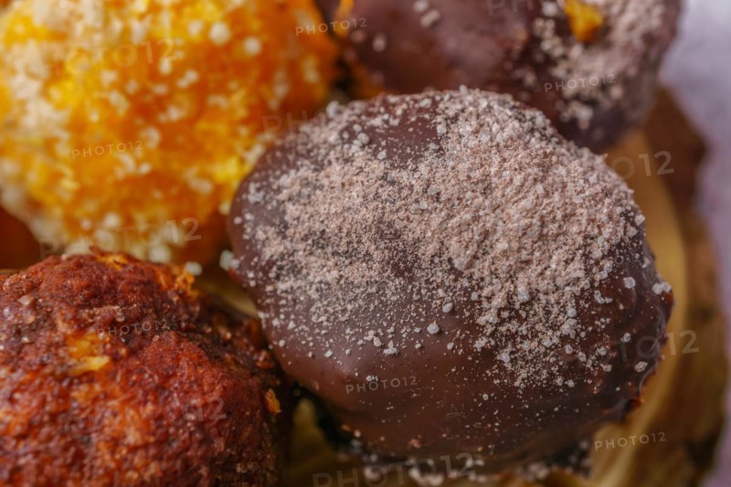 Close-up of sweet truffles of different flavors on a wooden disk