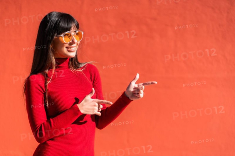 Brunette girl in a spring orange dress and sunglasses