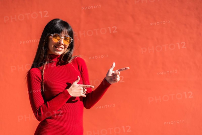 Brunette girl in an orange dress and sunglasses in spring
