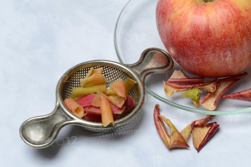 Apple peel tea in tea strainer and apple