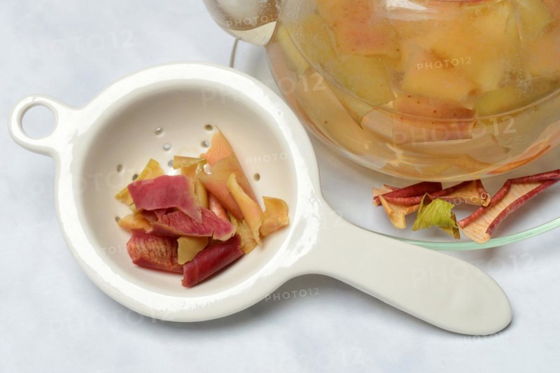 Apple peel tea in teapot and apple peel in tea strainer