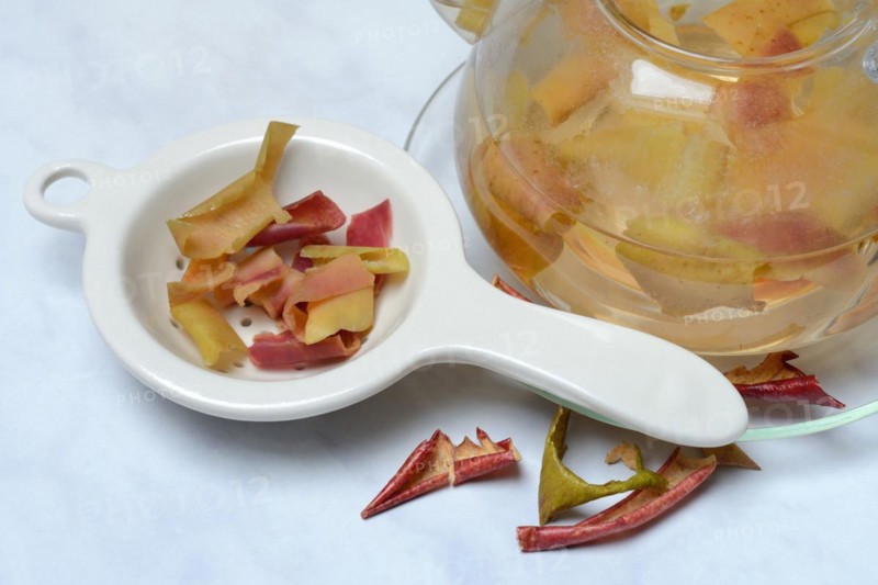Apple peel tea in teapot and apple peel in tea strainer