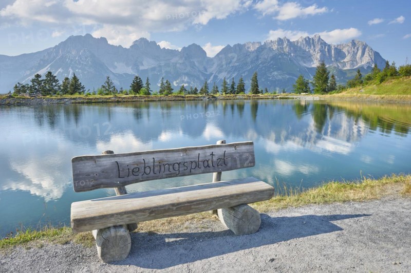 Bench in front of Astbergsee with reflection of the mountain panorama